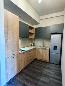 a kitchen with wooden cabinets and a white refrigerator at Tsaghkadzor Kechi Heights Retreat - Luxe Family Apartment in Tsaghkadzor