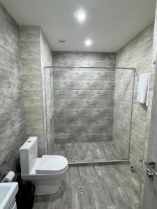 a bathroom with a toilet and a glass shower at Tsaghkadzor Kechi Heights Retreat - Luxe Family Apartment in Tsaghkadzor +32 photos