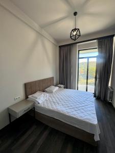 a bedroom with a large bed and a window at Tsaghkadzor Kechi Heights Retreat - Luxe Family Apartment in Tsaghkadzor
