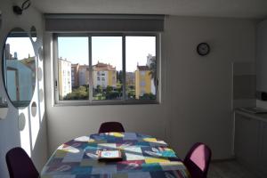 een tafel en stoelen in een kamer met een raam bij Appartement T2 Cap d'Agde in Cap d'Agde
