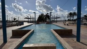 een zwembad met banken en palmbomen bij Oasis jacuzzi retreat in Marbella