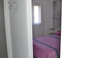 een slaapkamer met een paars bed en een raam bij Appartement T2 Cap d'Agde in Cap d'Agde +1 foto