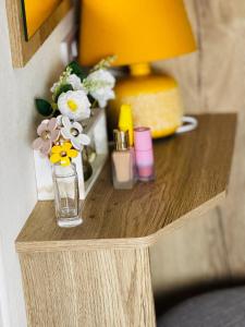 a table with a lamp and a vase of flowers on it at PV70 newquay bay resort in Newquay Bay Resort