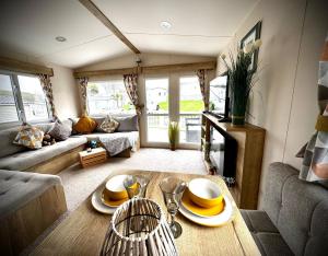 a living room with a table and a couch at PV70 newquay bay resort in Newquay Bay Resort