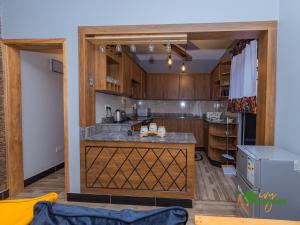 a kitchen with wooden cabinets and a large counter top at Ivy Homes - Kapchorwa in Kapchorwa