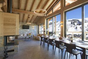 a dining room with a long table and a fireplace at Odalys Chalet Le Panda in Les Deux Alpes