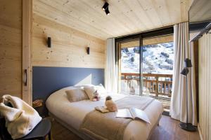 a bedroom with a bed with a teddy bear on it at Odalys Chalet Le Panda in Les Deux Alpes