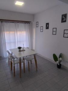 a dining room with a table and chairs and a window at Departamento 9 de Julio in Tandil