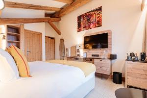a bedroom with a white bed and a tv at La Ferme du Golf in Megève