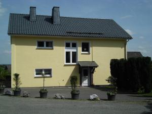 ein gelbes Haus mit schwarzem Dach in der Unterkunft Kaisers Ferienhof in Hallenberg