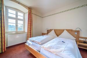 a bedroom with a large bed with a window at Schlosshotel Ravenstein in Unterwittstadt