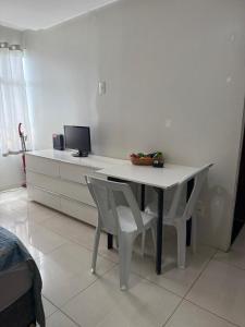 a white table with two chairs and a computer on it at Kitnet Asa Sul in Brasilia