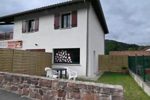a house with two chairs and a table in front of it at Gîte Gip Enea in Saint-Étienne-de-Baïgorry +1 photo