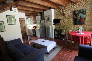 a living room with a table and a kitchen at Gites le Sud, La Petite Grange in Puybrun