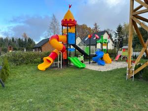 a playground with a slide in the grass at Na Jeziornej Domki Wypoczynkowe in Żarnowska