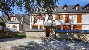 a large white house with a tree in front of it at Saplan Real Estate CALETA in Les