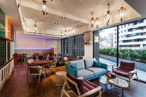 a living room with a couch and chairs and tables at Lacle Hotel-Luzhou Taipei in Taipei
