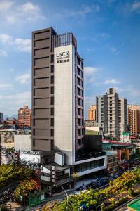 Ein hohes Gebäude mit einem Schild in einer Stadt. in der Unterkunft Lacle Hotel-Luzhou Taipei in Taipeh