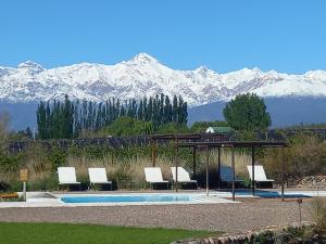 a pool with a gazebo and mountains in the background at Tupungato Divino in Tupungato