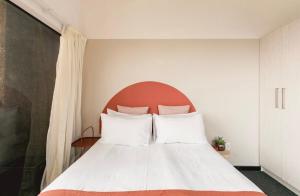 a bedroom with a white bed with a red headboard at COGE - Braamfontein - 2 Bedroom in Johannesburg