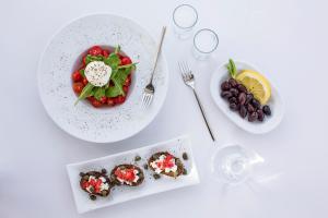 a white table with two plates of food on it at Contaratos Beach Hotel in Naousa