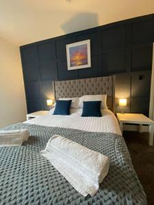 a bedroom with a large bed with blue pillows at Flat2 large modern King Bed Flat, private bathroom Ryan's place in Walton on the Hill