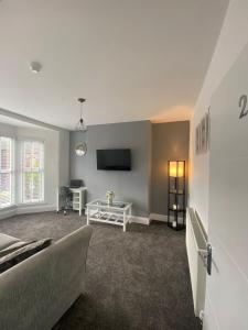 a living room with a couch and a tv at Flat2 large modern King Bed Flat, private bathroom Ryan's place in Walton on the Hill +15 photos