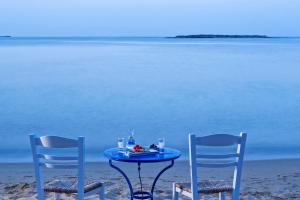 two chairs and a table on the beach at Contaratos Beach Hotel in Naousa