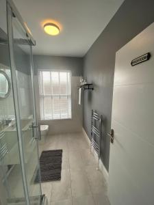 a bathroom with a glass shower and a toilet at Flat2 large modern King Bed Flat, private bathroom Ryan's place in Walton on the Hill