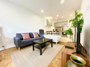 a living room with a blue couch and a table at BnGo I Le Spacieux I 3 chambres, 2 salles de bain, 1 toilette, parking privé gratuit, 8 personnes, Vieux Lyon hypercentre in Lyon