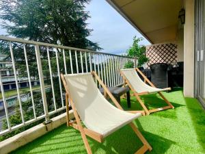 two chairs sitting on a balcony with green grass at BnGo I Le Spacieux I 3 chambres, 2 salles de bain, 1 toilette, parking privé gratuit, 8 personnes, Vieux Lyon hypercentre in Lyon