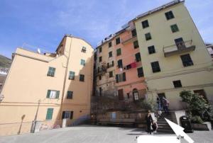 two buildings next to each other with people standing between them at Rio Alba blu loft - holiday house 5 terre Riomaggiore in Riomaggiore