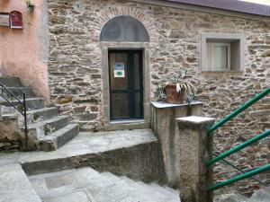 a stone building with a door and stairs at Shanti 3 - Riomaggiore private room in Riomaggiore