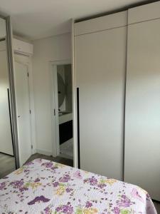 a bedroom with a bed and a mirrored closet at Suíte privada Mariscal in Bombinhas +1 photo