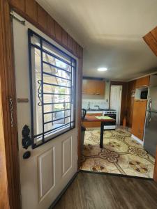 an open door to a kitchen with a table at Céntrica y Hermosa Casa Apartamento in Puerto Varas