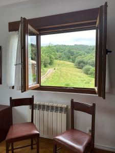 2 sillas frente a una ventana con vistas en Casa con jardín a pie de playa y montaña, en Panes 27 fotos más