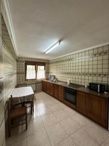 Una cocina grande con una mesa y un fregadero. en Casa con jardín a pie de playa y montaña, en Panes