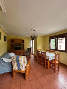 Un dormitorio con una cama y una mesa y sillas. en Casa con jardín a pie de playa y montaña, en Panes