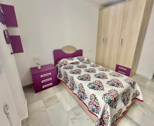 Dormitorio pequeño con cama y armario púrpura en Refugio Costero, en Calahonda 9 fotos más