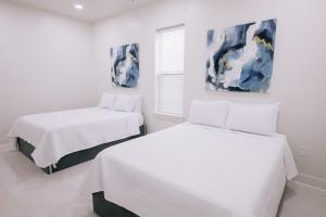 Dos camas en una habitación con paredes blancas. en Magic canal, en Nueva Orleans