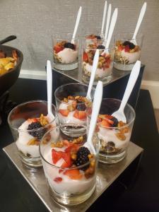 a group of bowls of dessert with white spoons in them at Detroit Marriott Livonia in Livonia