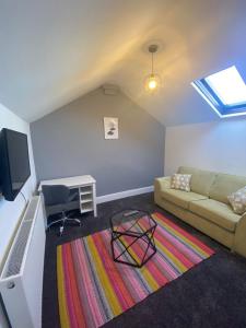 a living room with a couch and a desk at Flat3 large modern king Bed flat private bathroom ryan's place in Walton on the Hill