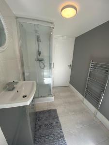 a white bathroom with a shower and a sink at Flat3 large modern king Bed flat private bathroom ryan's place in Walton on the Hill