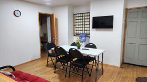 une pièce avec une table avec des chaises et une télévision dans l'établissement Arriendo de Verano 4 dormitorios, à Valparaíso