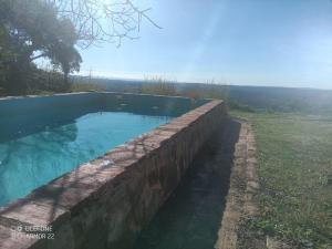 a stone retaining wall around a swimming pool at Bonita Casa Rural Sierra Norte in El Pedroso +13 photos