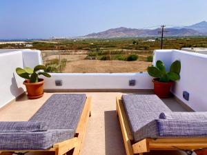 balcón con 2 mesas y vistas al desierto en Apleton Suites, en Agia Anna de Naxos