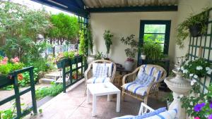 a patio with two chairs and a table at Les Chenes Chambres D'hote in Châtel-Guyon