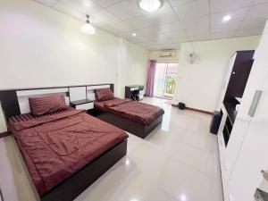 een slaapkamer met twee bedden in een kamer bij Jaroon House in Samutprakarn