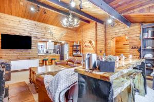 ein Wohnzimmer aus Blockhaus mit einem Tisch und einem TV in der Unterkunft 5 Mi to Breckenridge Ski Resort Cozy Wood Cabin! in Breckenridge
