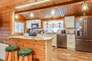 eine Küche mit Holzwänden und einer Theke mit Hockern in der Unterkunft 5 Mi to Breckenridge Ski Resort Cozy Wood Cabin! in Breckenridge